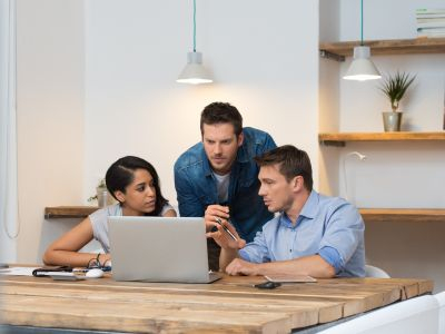 3 werknemers overleggen voor een laptop