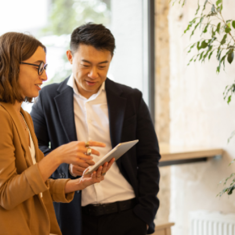 Twee collega's bekijken informatie op tablet